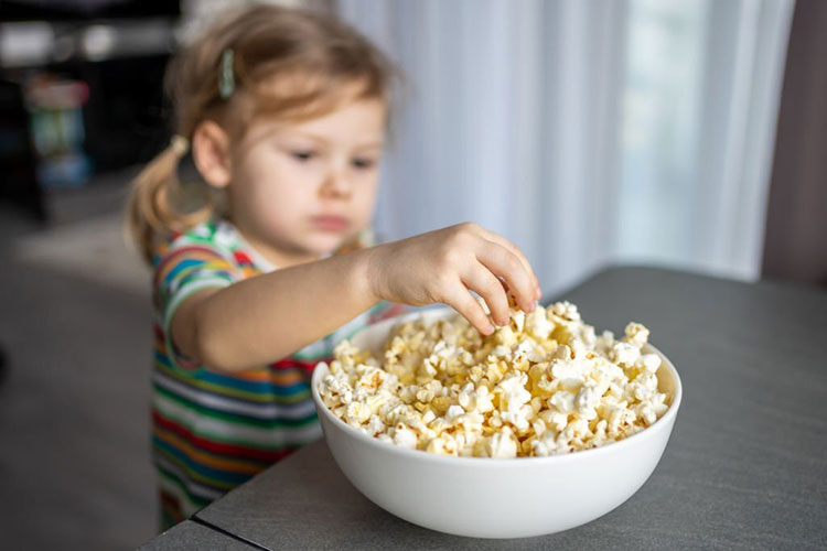 baby eating popcorn